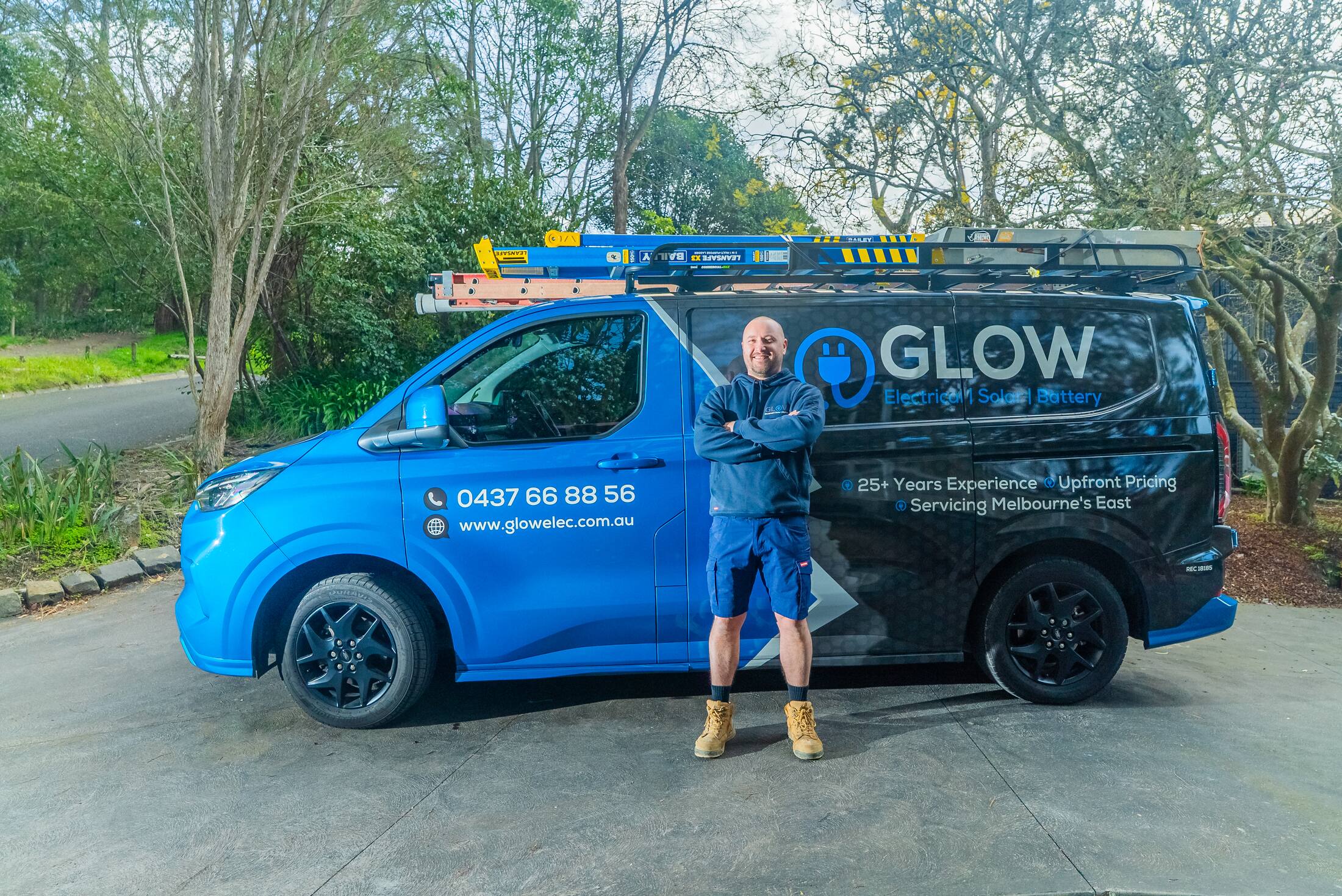 The Glow Electrical van parked on a Ringwood East driveway, with Michael alongside it