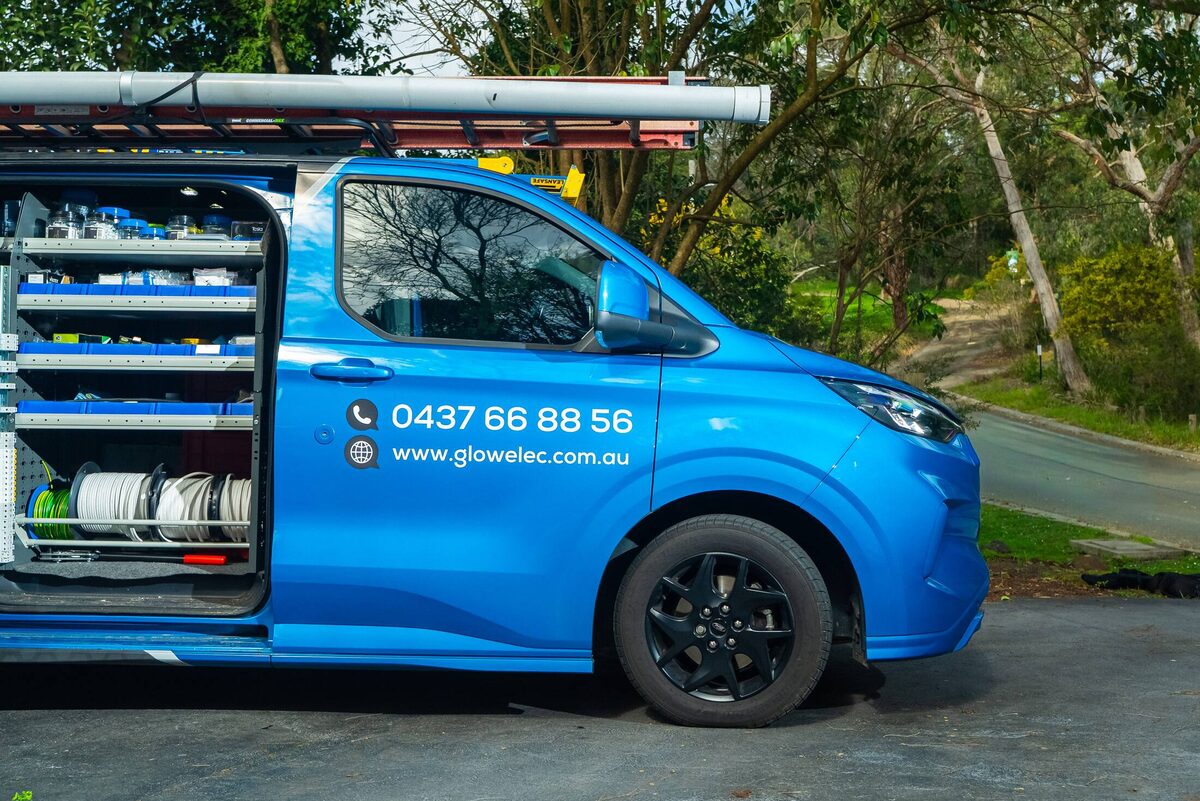 The Glow Electrical van open on a Ringwood East driveway, shelves stocked with cable and fittings