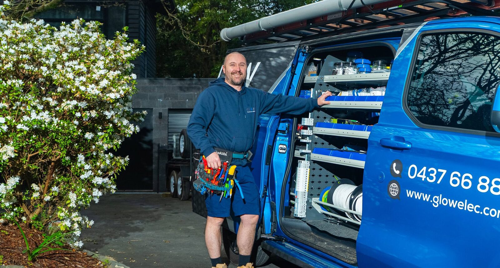 Michael at the open door of the stocked Glow van with his tool belt on